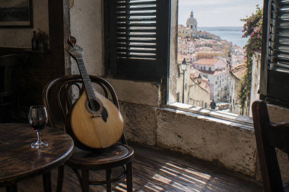 Portuguese guitarra resting on a chair beside a glass of port wine