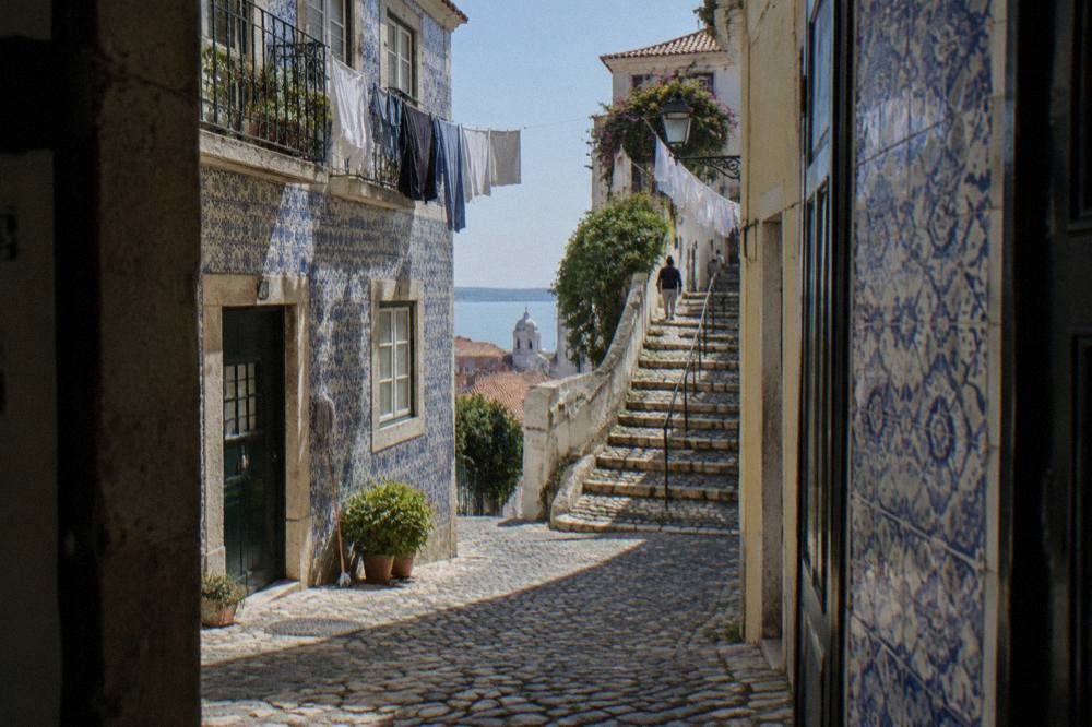 Narrow cobbled street in Alfama with old tiled facades