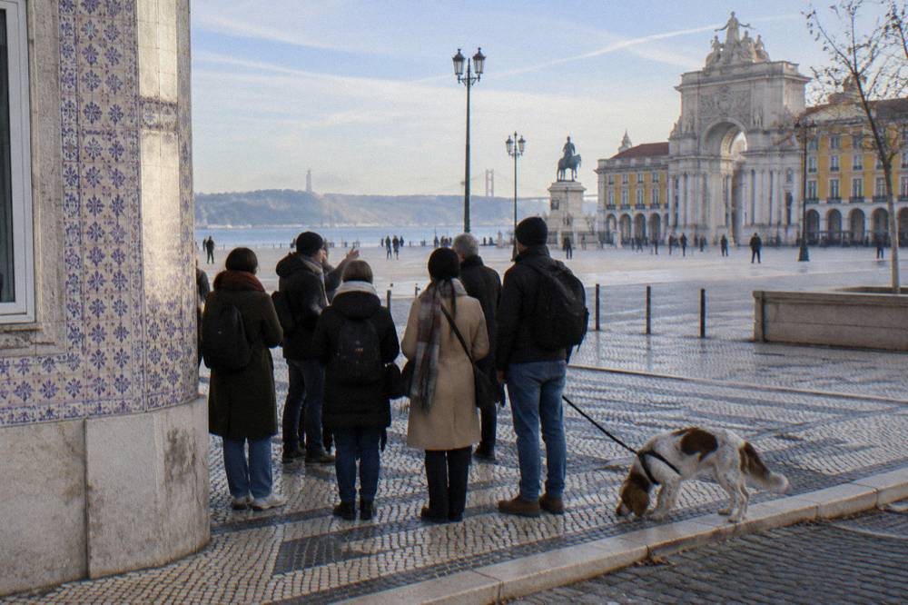 A small group of tourists listening to a guide in front of a historic tiled building in Lisbon's Chiado district