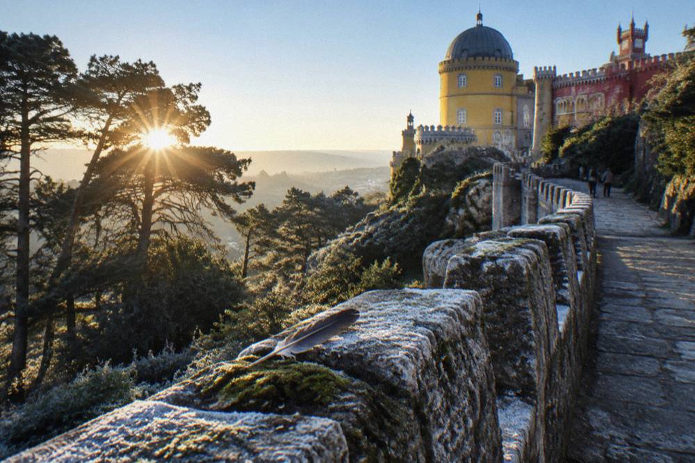 Stone ramparts of a Moorish castle above pine forest
