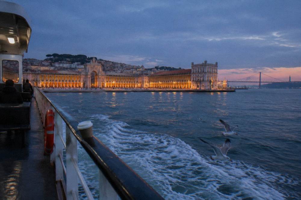 Evening light on the Tagus river with Lisbon's riverside buildings and bridge in the distance