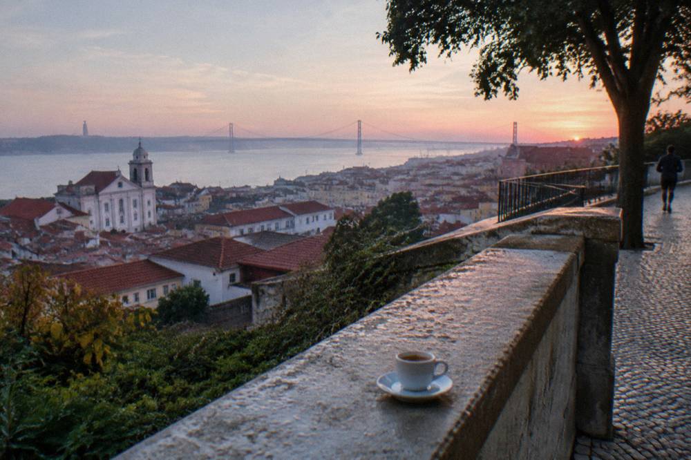A viewpoint terrace overlooking red rooftops and the Tagus river