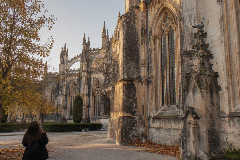 A Gothic monastery with ornate stone carving and tall lancet windows beside a quiet courtyard