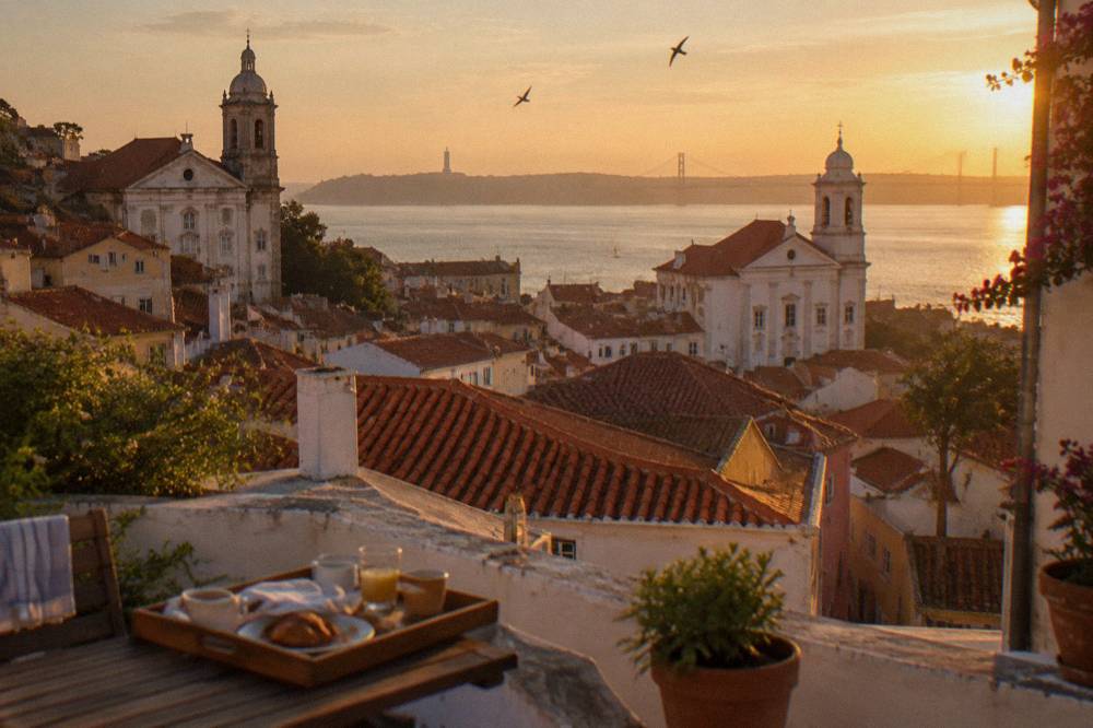 Terracotta rooftops and church towers of Lisbon in warm evening light