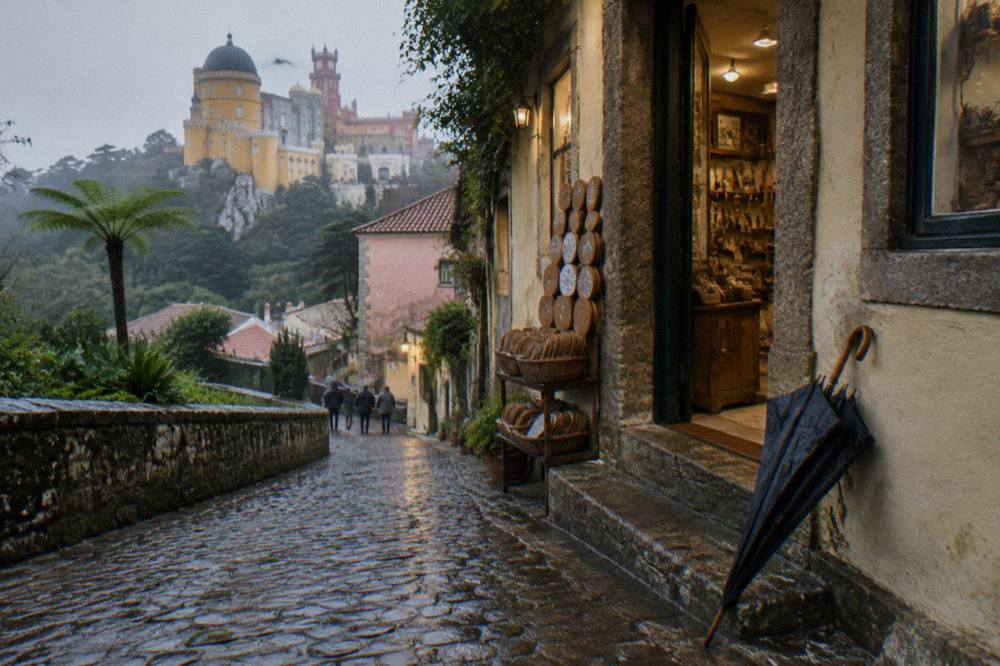 A narrow cobbled lane in Sintra's old town lined with traditional shops
