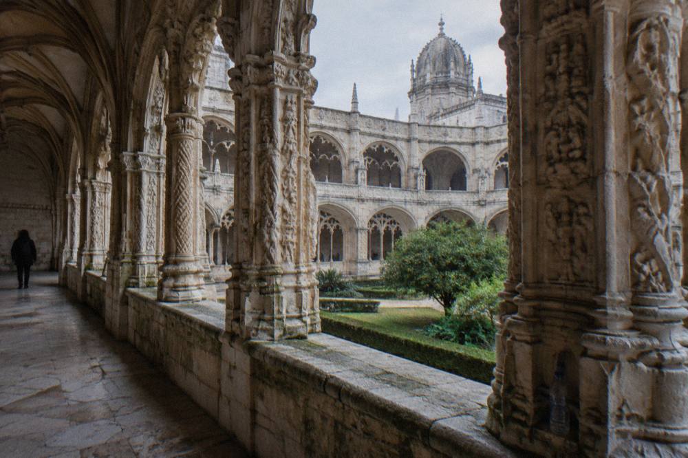 Stone arcade of the Jerónimos Monastery cloister with carved Manueline columns and soft daylight