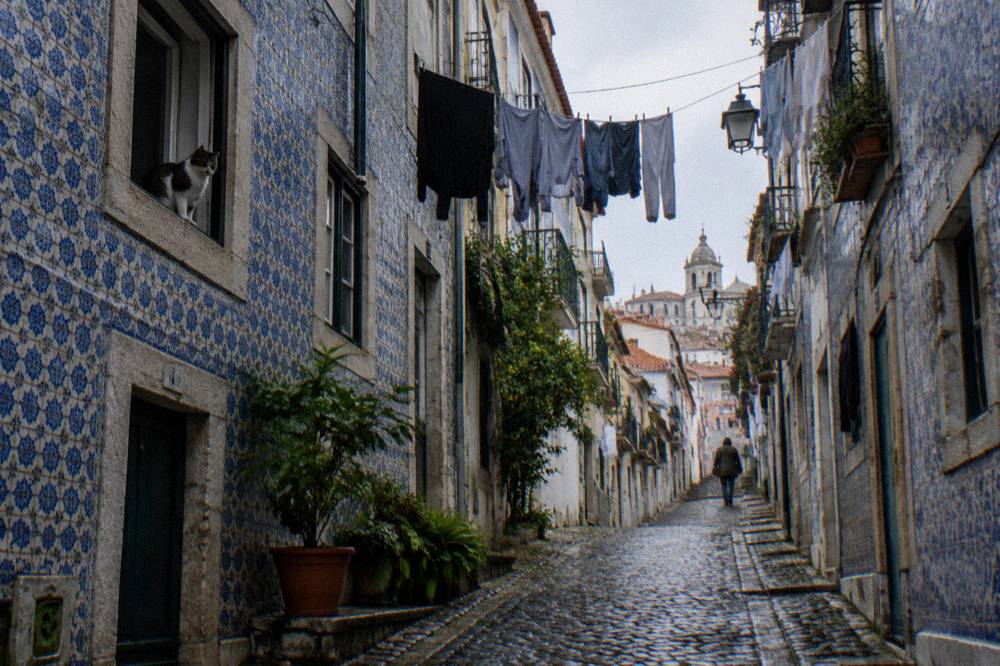 Narrow Alfama street with laundry overhead and few people