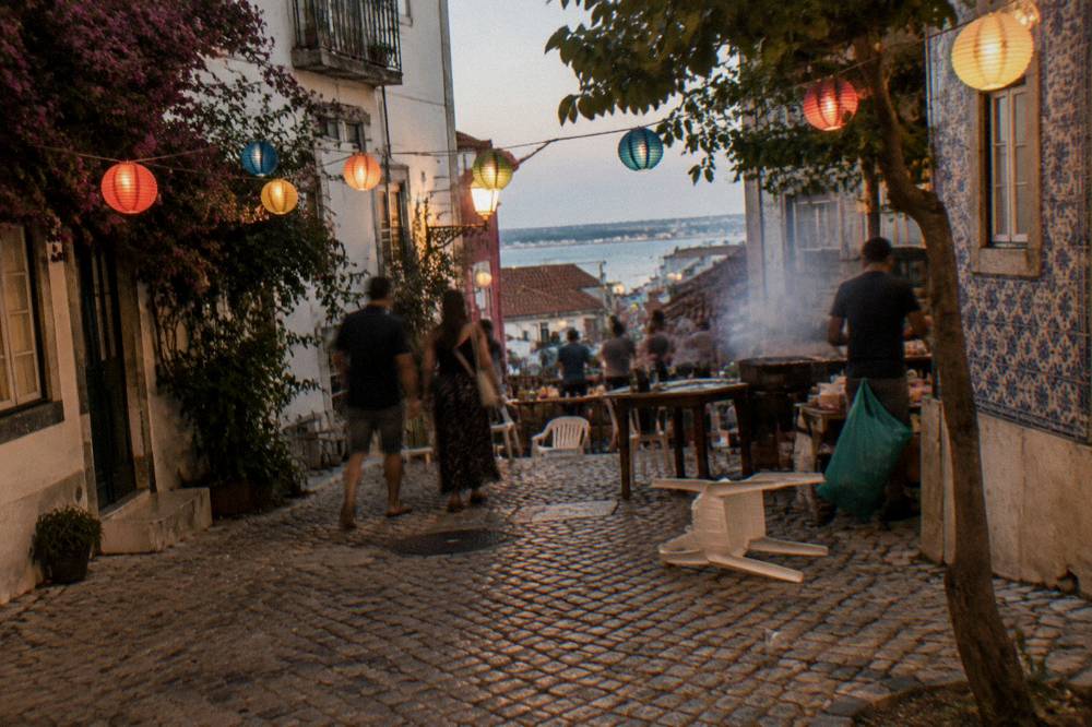 Evening street party with lights strung over a Lisbon square