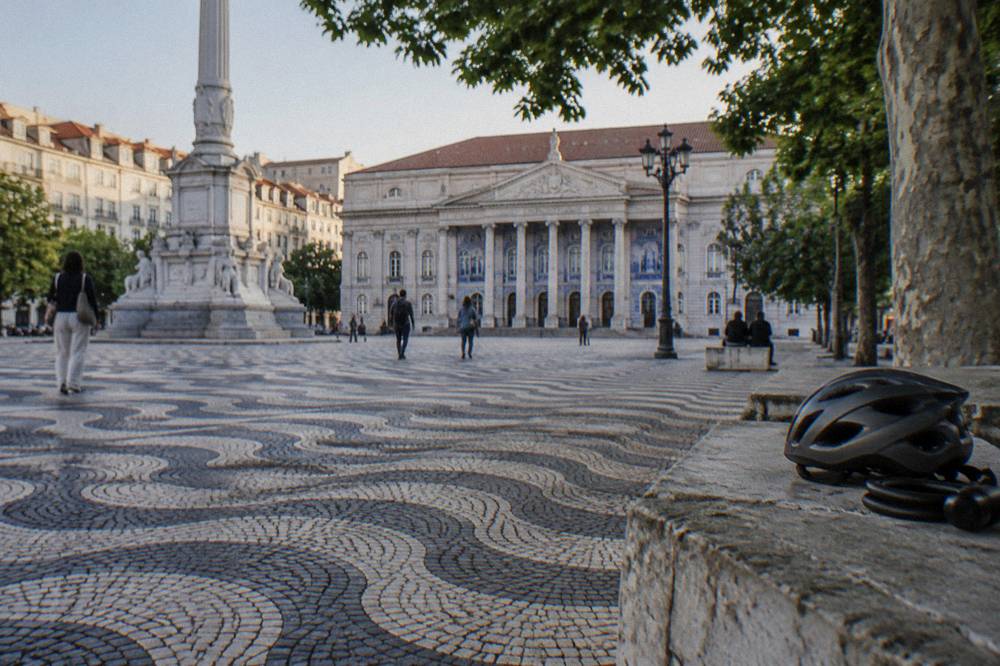 Electric bicycles parked on a cobbled square beside a historic building facade