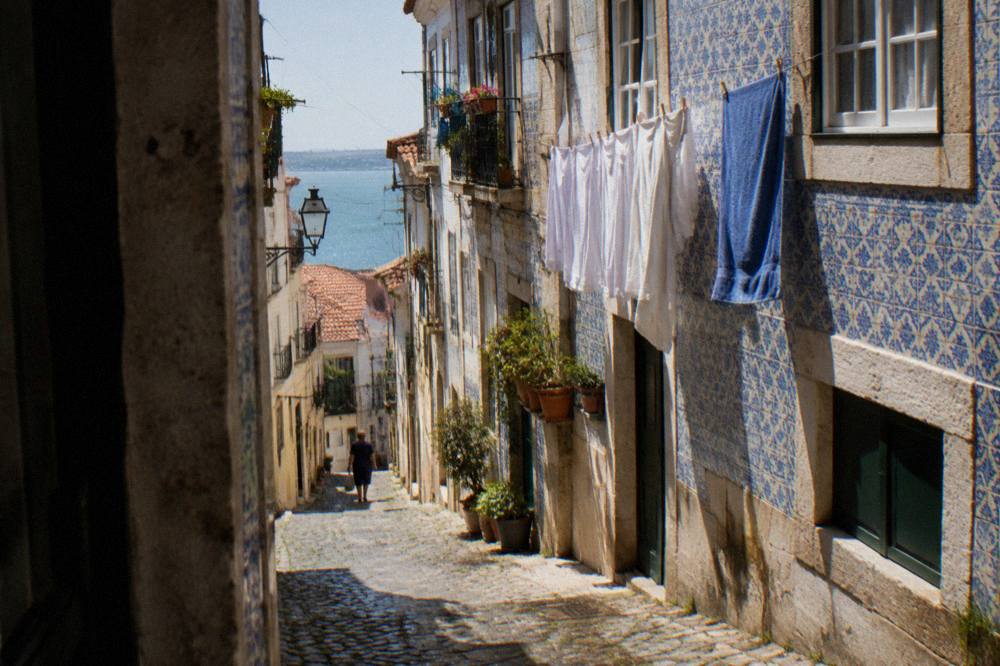 Washing lines strung between old tiled facades in a steep Alfama lane