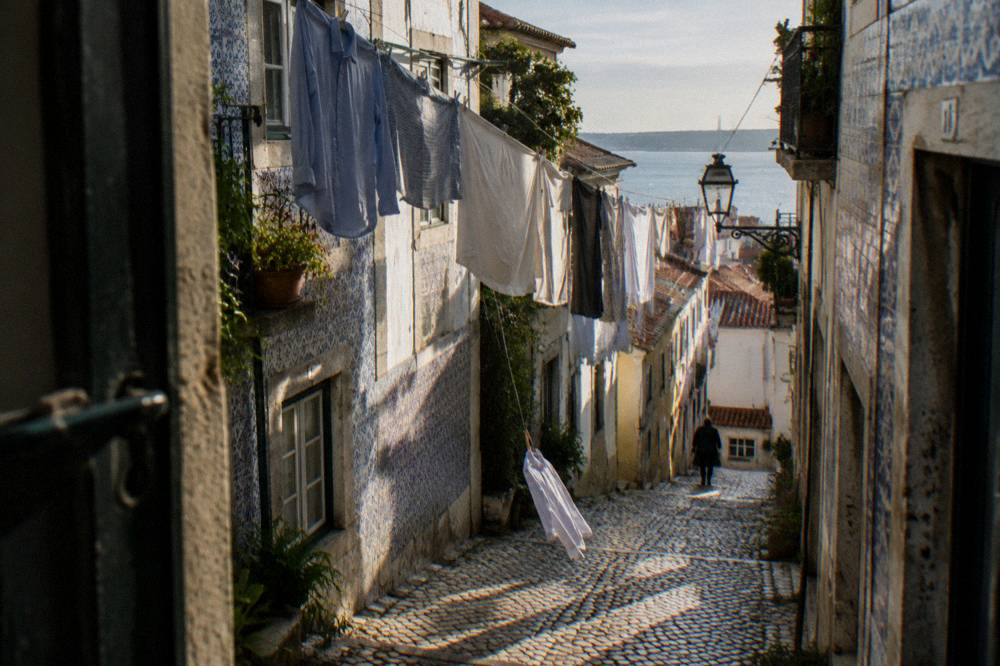 Narrow cobbled street in Alfama with laundry strung between buildings