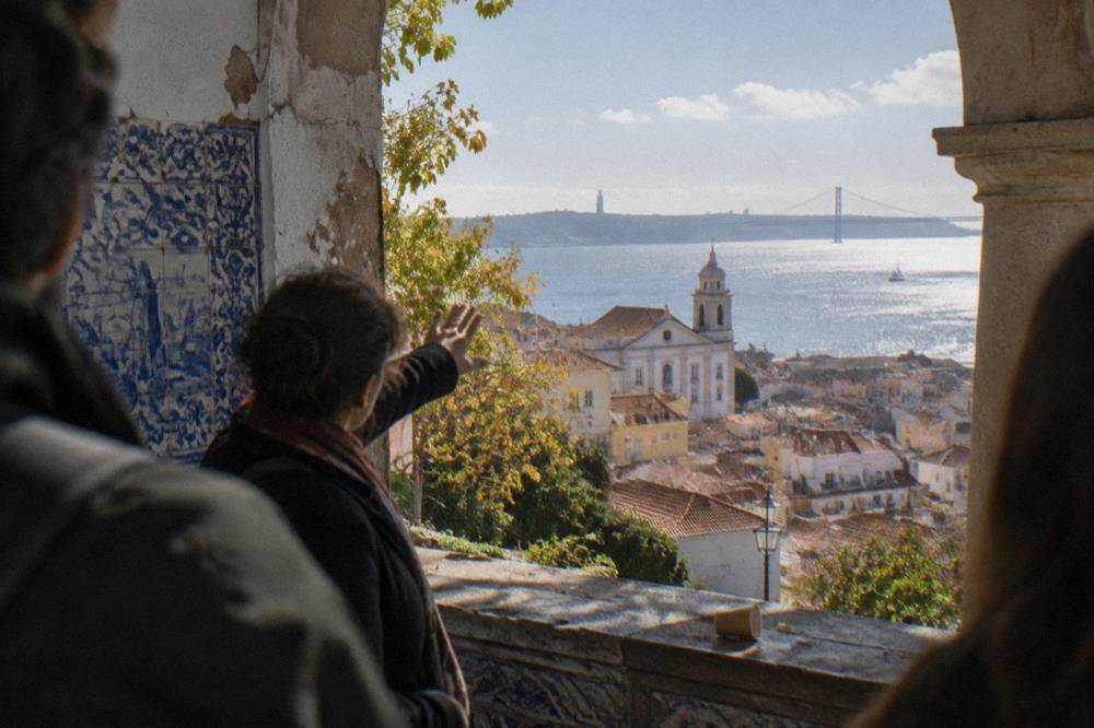 Guide speaking to a small group at a Lisbon miradouro overlooking the river