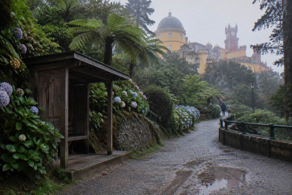 Wooden bus shelter and winding road at the Pena Palace park entrance