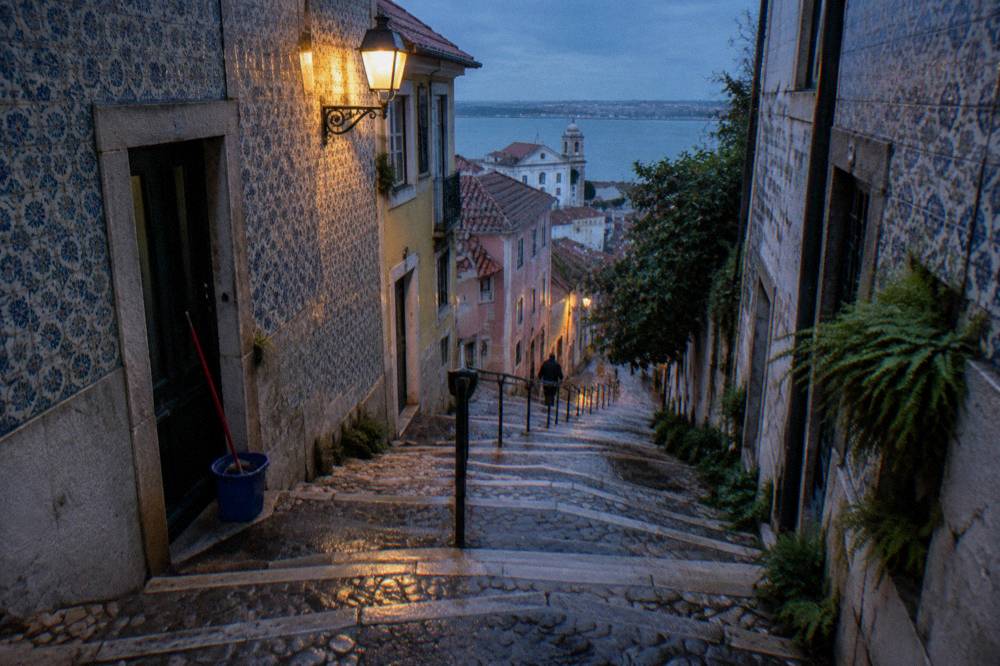 Winding tiled staircase street in Lisbon old town climbing between buildings