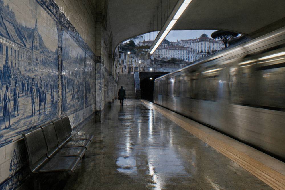 Lisbon metro station platform with tile-lined walls and a modern train
