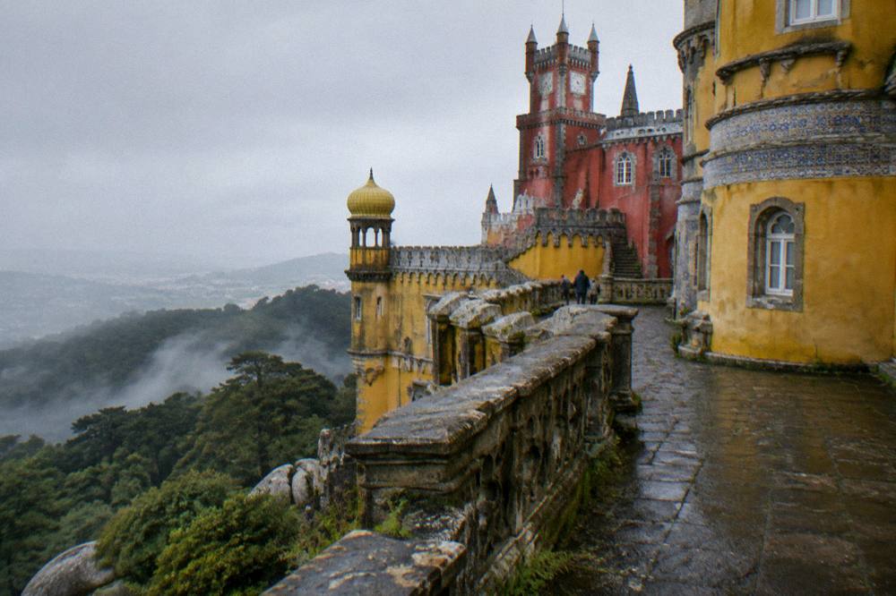 Colourful Pena Palace terraces above the Sintra hills with forest below