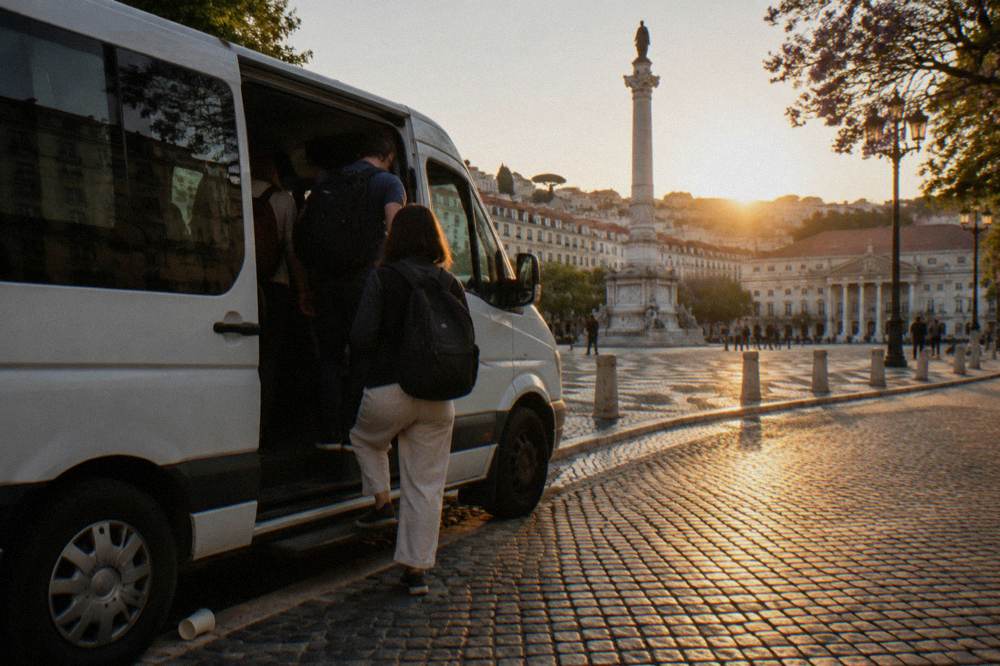 A passenger van parked on a cobbled Lisbon street waiting for tour guests
